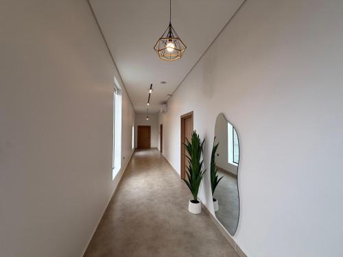 a hallway with white walls and a potted plant at The Balance Retreat in Būbādī