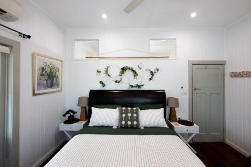 a bedroom with a bed and two nightstands at Heavenly Palms on Collinson in Westcourt