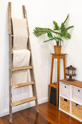 a wooden ladder next to a table with a plant at Heavenly Palms on Collinson in Westcourt