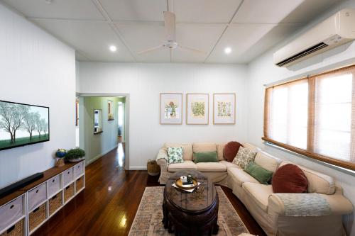 a living room with a couch and a tv at Heavenly Palms on Collinson in Westcourt