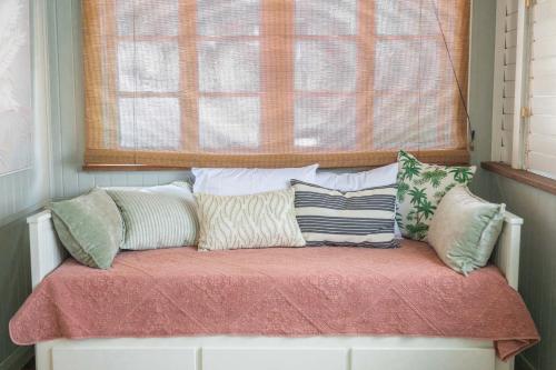 a bench with pillows sitting in front of a window at Heavenly Palms on Collinson in Westcourt