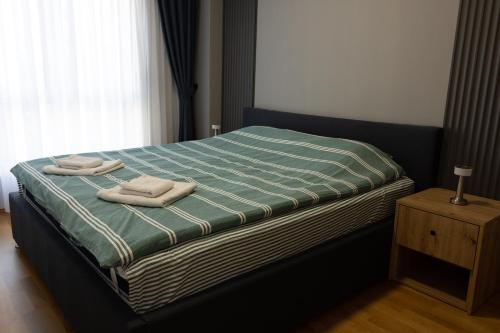 スコピエにある4th floor Aleksandra apt East Gate Mall free parking near Old Bazaarのベッドとタオル2枚のある寝室