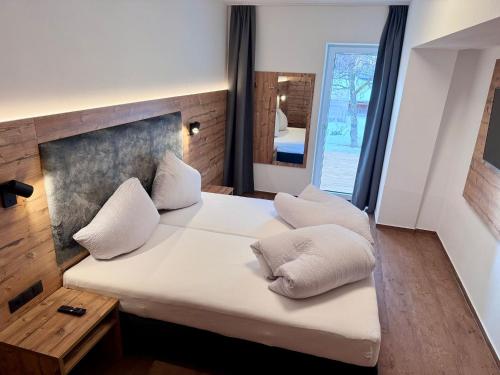 a bedroom with a large bed with white pillows at Home's am Hof in Nauders