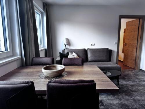 a living room with a wooden table and a couch at Home's am Hof in Nauders