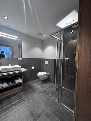 a bathroom with a shower and a sink and a toilet at Home's am Hof in Nauders
