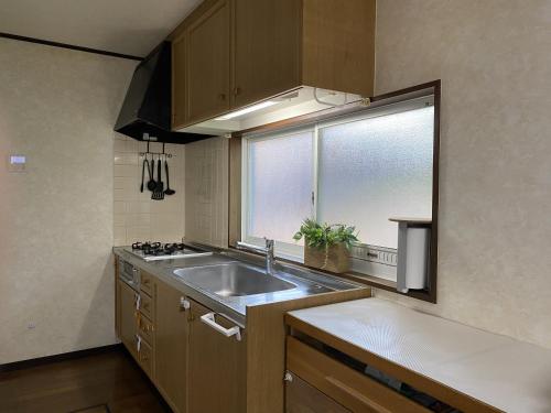a kitchen with a sink and a window at 大和base in Kaga