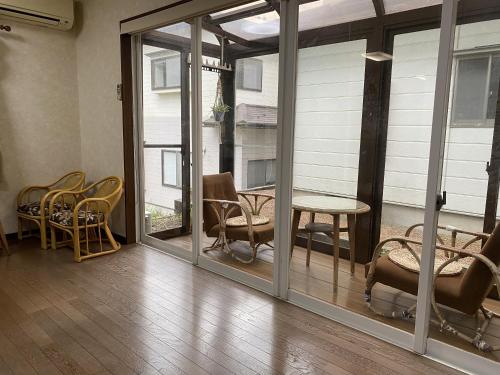 a room with glass doors and a table and chairs at 大和base in Kaga