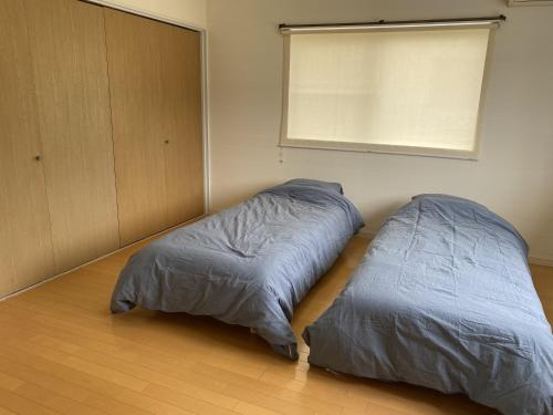 two beds in a room with a window at 大和base in Kaga