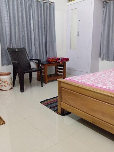a bedroom with a bed and a chair and a table at Blessing Homestay in Pūvār