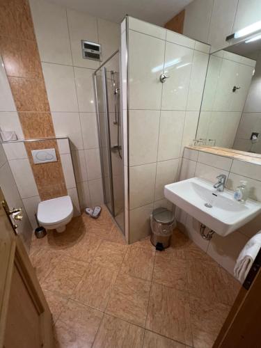 a bathroom with a shower and a sink and a toilet at Hotel Garni Gafluna in Sankt Anton am Arlberg