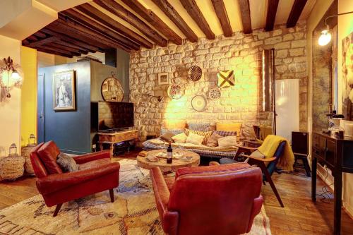 - un salon doté de meubles et d'un mur en pierre dans l'établissement Bluestay 508 - Flat With Terrasse at st Germain, à Paris