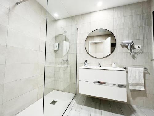 Un baño blanco con lavabo y espejo. en FTV Holidays Homes - Casa Relán, en La Oliva