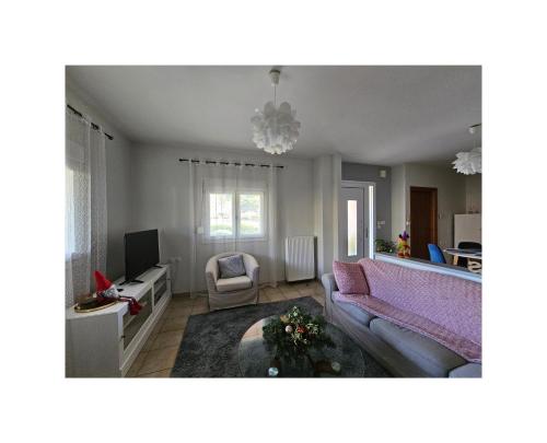 a living room with a couch and a tv at Αγροικία Mυλόδεση in Kalavrita
