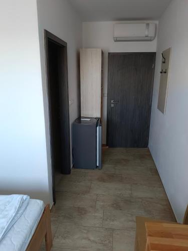 a hallway with a door and a room with a refrigerator at Penzion Mušov in Pasohlávky