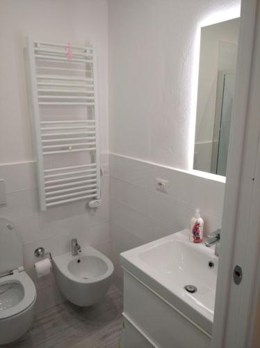 a white bathroom with a sink and a toilet at Trilocale San Vincenzo in San Vincenzo