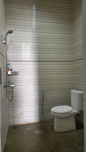 a bathroom with a toilet and a shower at Villa kusuma pinus M-59 in Batu