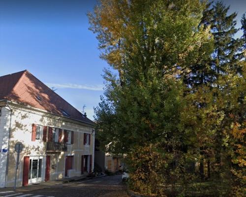 un arbre à côté d'un bâtiment blanc et un arbre dans l'établissement Appartement à la montagne, à Saint-Bonnet-en-Champsaur