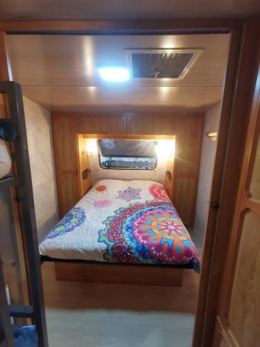 - un lit au milieu d'une petite pièce dans l'établissement Caravane 4 personnes au camping d'Aussois, à Aussois