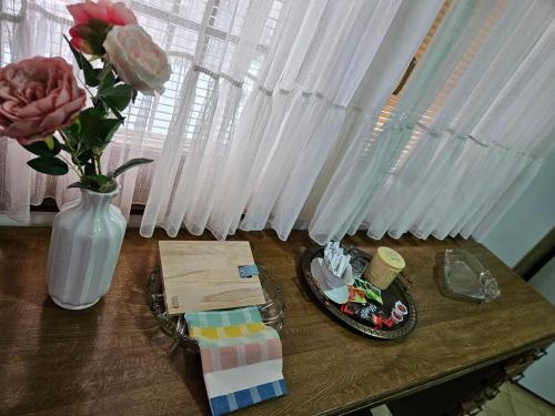 a table with a vase and a plate of food and flowers at Elsas Residence in Sarajevo