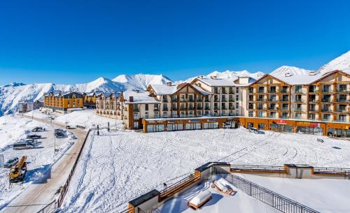 a resort with snow covered mountains in the background at New Gudauri Loft 2 Pines in Gudauri
