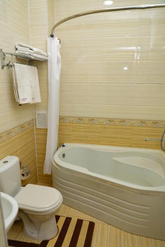 a bathroom with a tub and a toilet and a sink at Said Islom Khoja in Khiva