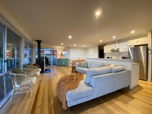 a large living room with a couch and a kitchen at Samphire Stays at Foul Bay in Marion Bay