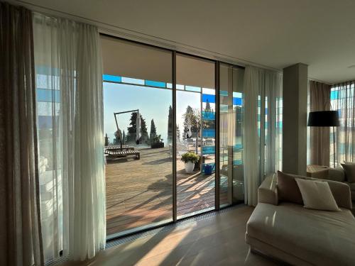 a living room with a couch and a large glass window at Eden Reserve Hotel in Gardone Riviera