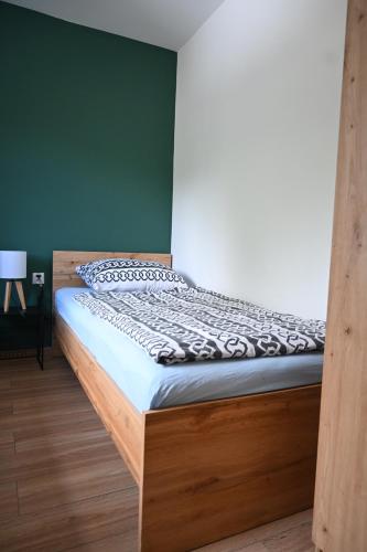 a bed with a wooden frame in a room at Pokoje Gościnne Przy Lesie in Pobiedna