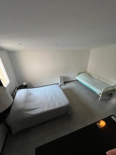 Cette chambre comprend un lit et un banc. dans l'établissement Grand appartement avec terrasse centre ville Arles, à Arles