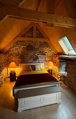 une chambre avec un grand lit dans un mur de pierre dans l'établissement Au cœur du quartier historique, à Lannion