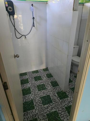 a bathroom with a toilet and a tiled floor at Sai Rung Farmstay สายรุ้ง ฟาร์มสเตย์ in Ban Huai Yung