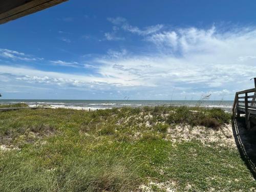 a view of a beach with a bench and the ocean at Sunflower 3 in St. George Island