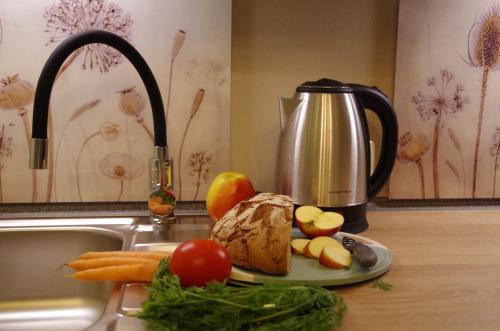 a plate of bread and fruits and vegetables on a kitchen counter at gemütliches Tiny House mit Kamin und Sauna in Steina