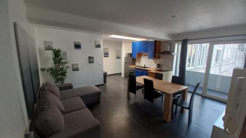 un salon et une cuisine avec un canapé et une table dans l'établissement Appartement entier 2 chambres 5 Cateau, à Roubaix