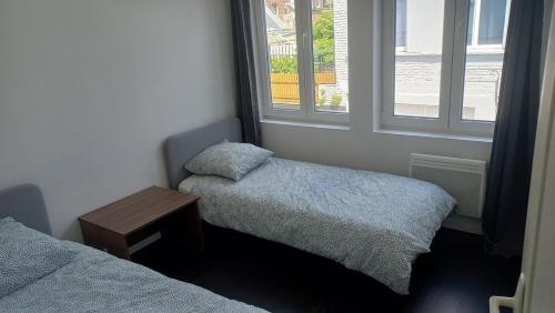 une petite chambre avec deux lits et une fenêtre dans l'établissement Appartement entier 2 chambres 5 Cateau, à Roubaix