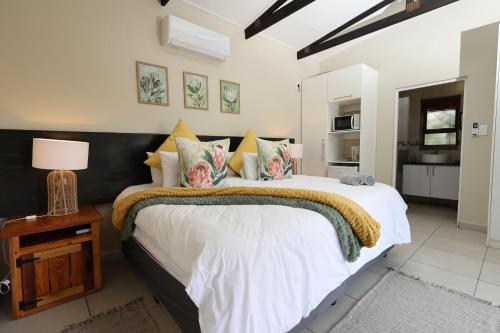 a bedroom with a large bed and a table with a lamp at Hhusha Hhusha in Malelane