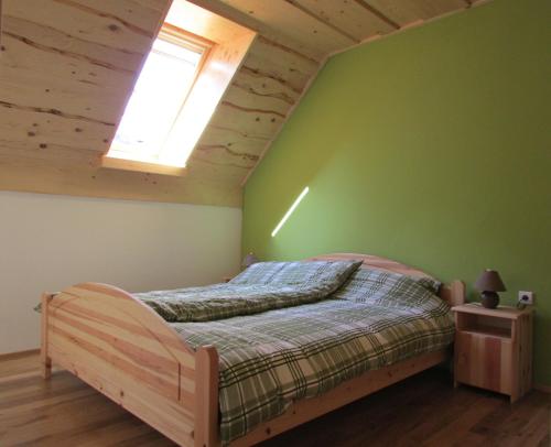 a bedroom with a bed in a green wall at Apartmaji Koželj in Ribnica na Pohorju