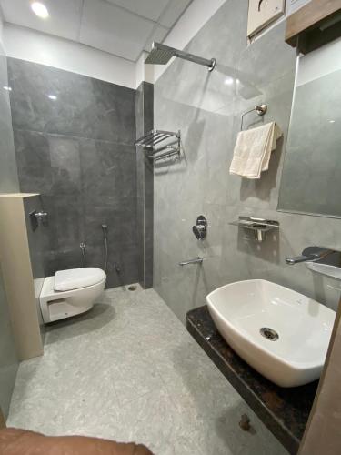 カーンプルにあるHotel Liyan Innの白い洗面台とトイレのあるバスルーム