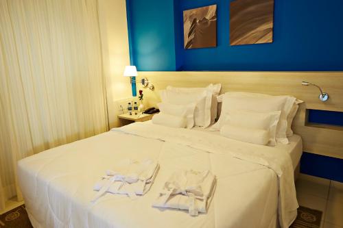 a hotel room with a large white bed with towels on it at Comfort Hotel & Suites Natal in Natal
