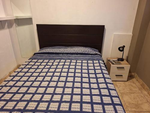 a bedroom with a bed with a black and white bedspread at Hostel rivendell lima in Lima