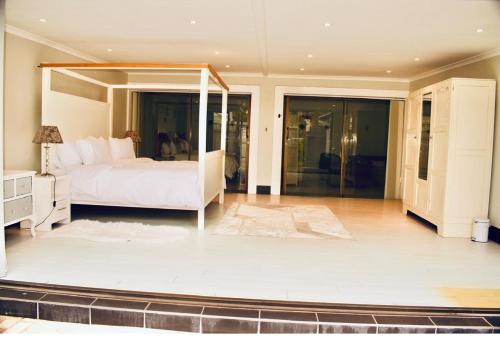 a bedroom with a large bed and glass doors at Serenity Stay- Walmer in Gqeberha