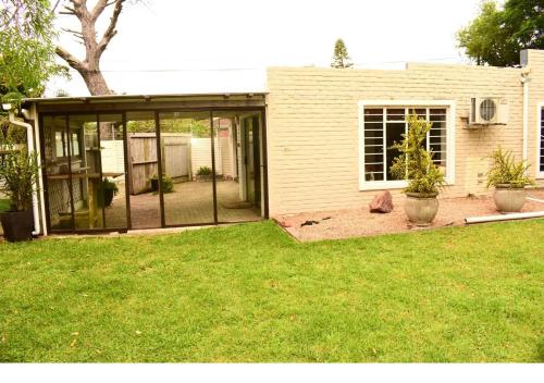 a screened in porch of a house with a yard at Serenity Stay- Walmer in Gqeberha