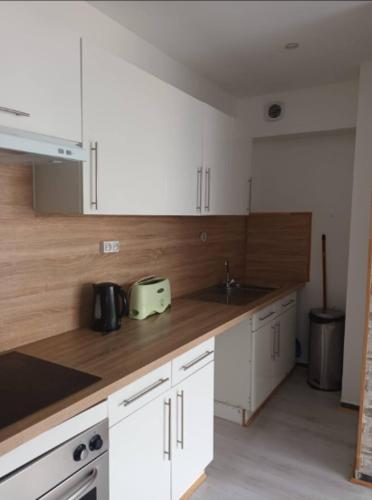 une cuisine avec des armoires blanches et un évier dans l'établissement Appart no2 motte T3 Secure Parking, à Tourcoing
