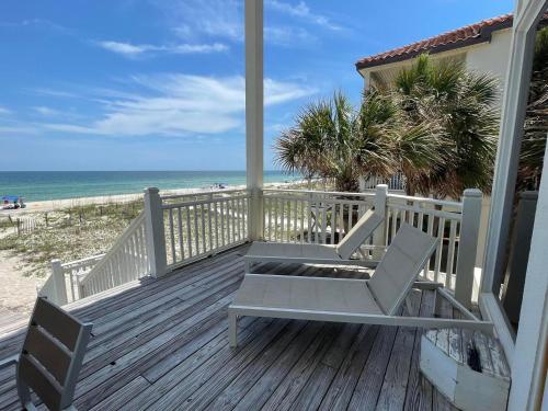 a porch with two chairs and the beach at 1st to the Beach-Sunset Beach-Beachfront-Pet Friendly-Hot Tub in St. George Island