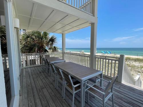 a porch with a table and chairs on the beach at 1st to the Beach-Sunset Beach-Beachfront-Pet Friendly-Hot Tub in St. George Island