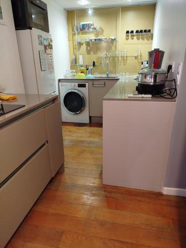 une cuisine avec un évier et une machine à laver dans l'établissement Chambre chez l'habitant à Paris centre, à Paris