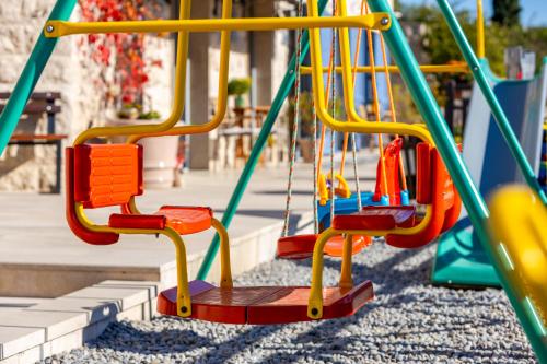 a playground with a slide in a park at Apart hotel M S KATUNJANIN in Herceg-Novi