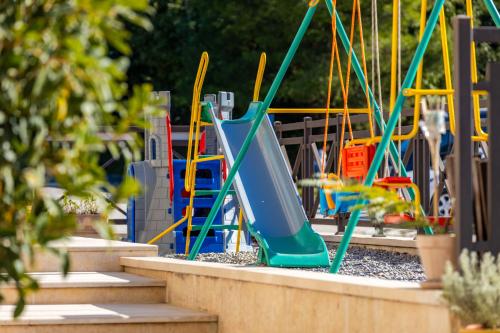 a playground with a slide in a park at Apart hotel M S KATUNJANIN in Herceg-Novi