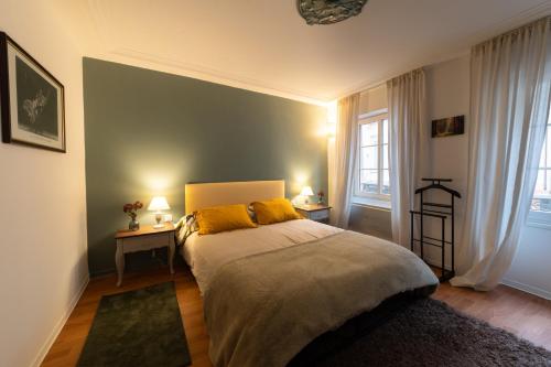 une chambre avec un lit avec des oreillers jaunes dessus dans l'établissement Nid d'émeraude - Votre escale cosy à Haguenau, à Haguenau