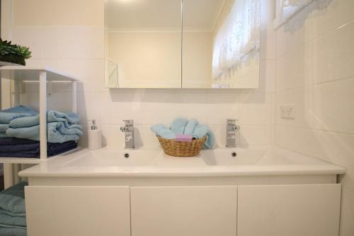 a bathroom with a sink and a basket of towels at Rosebud Comfort Retreat in Rosebud